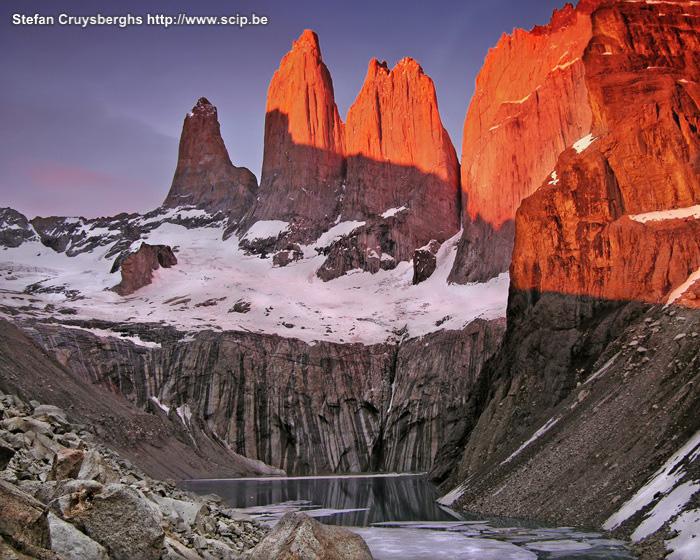 Torres del Paine - Zonsopgang De drie torens van Paine zijn gigantische granieten monolieten die gevormd zijn door de kracht van gletsjerijs. Bij zonsopgang baden deze rotsen in het oranje rode zonlicht. Voor rotsklimmers zijn de Torres de bekendste uitdaging in het Paine National Park. Stefan Cruysberghs